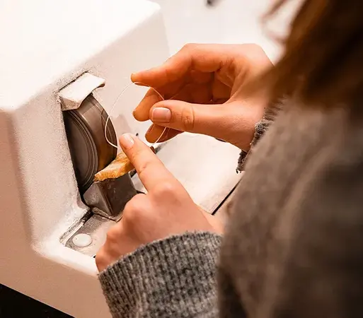 Hände schleifen Schmuckstück an Poliermaschine, Goldschmied Werkstatt